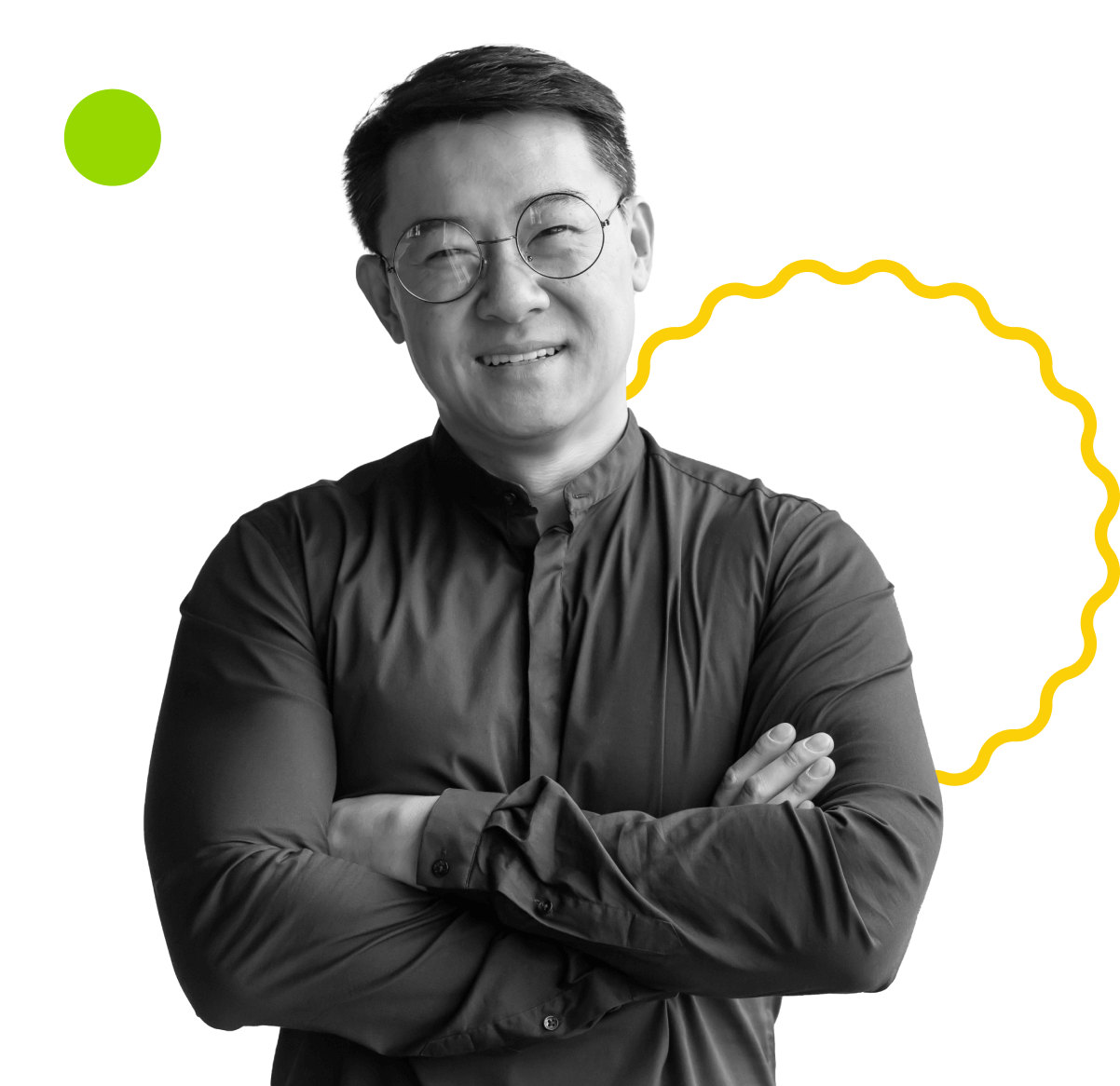 A man with short hair and glasses smiles confidently with arms crossed. The image has a black-and-white filter, with abstract graphic elements including a white circle, a green dot, and a yellow wavy line in the background.