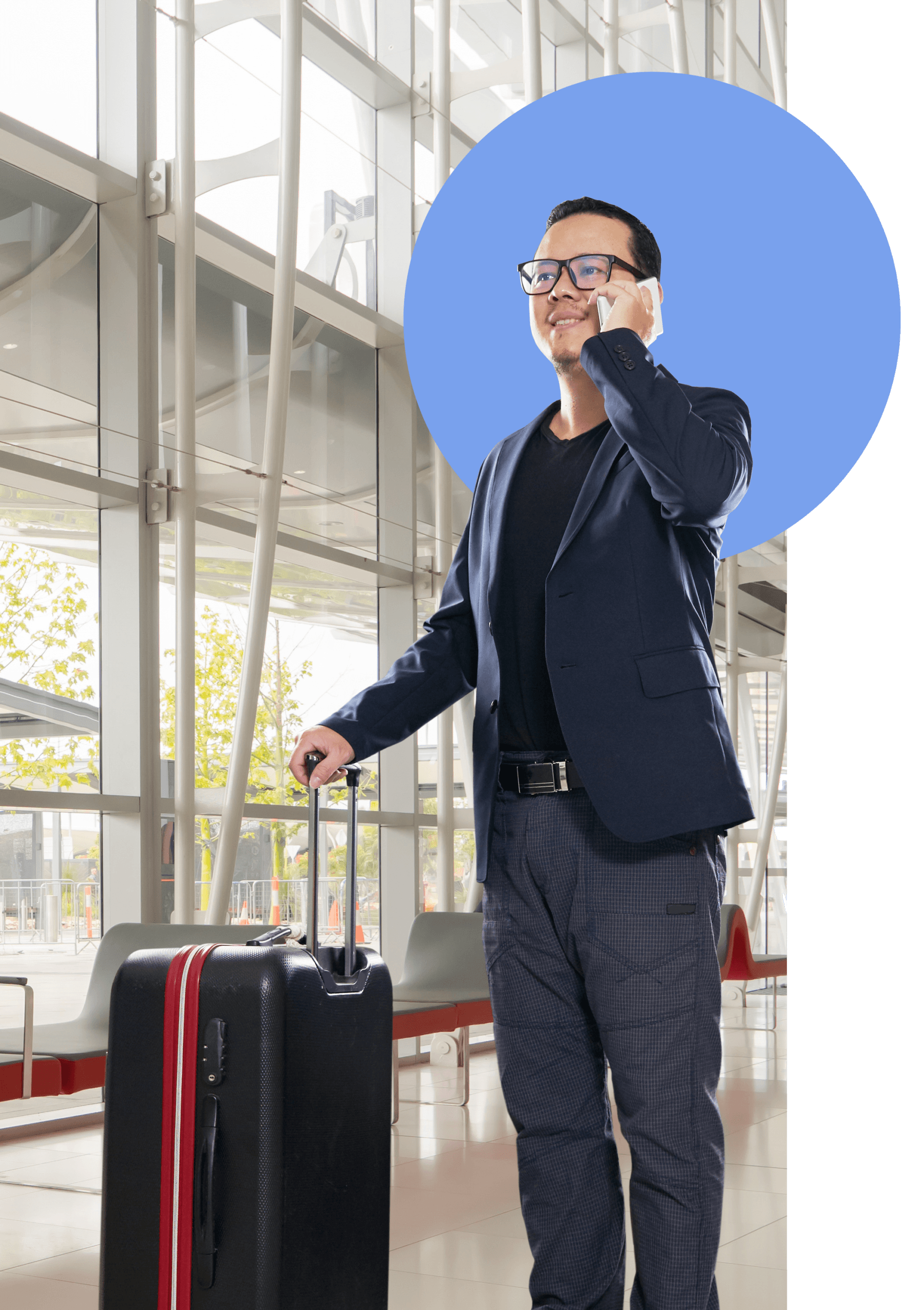 A man in a blue blazer and light sweater smiles while standing in an airport, holding a smartphone and suitcase, with a crossbody bag over his shoulder. A large blue circle is behind him.